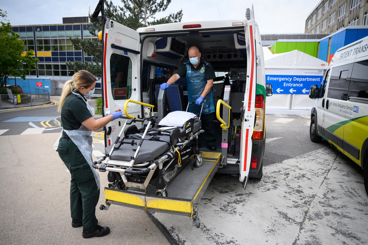 Katie Ffolloitt-Powell and Mike Carr of the Patient Transport Services of South Central Ambulance Services prepare to move an elderly non-COVID-19 patient from hospital to a care home, in Portsmouth, Britain May 5, 2020. Picture taken May 5, 2020. Leon Neal/Pool via REUTERS