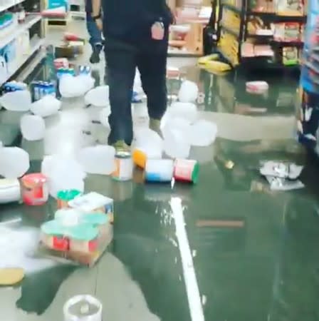 A man walks through the items on market's floor following an earthquake in Ridgecrest