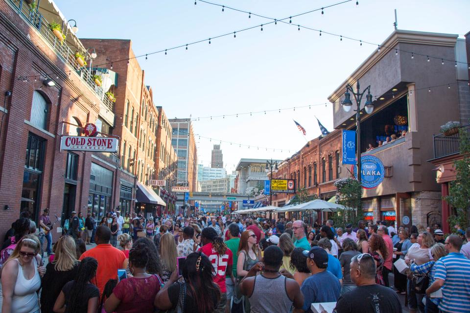 People along Monroe Street in Greektown.