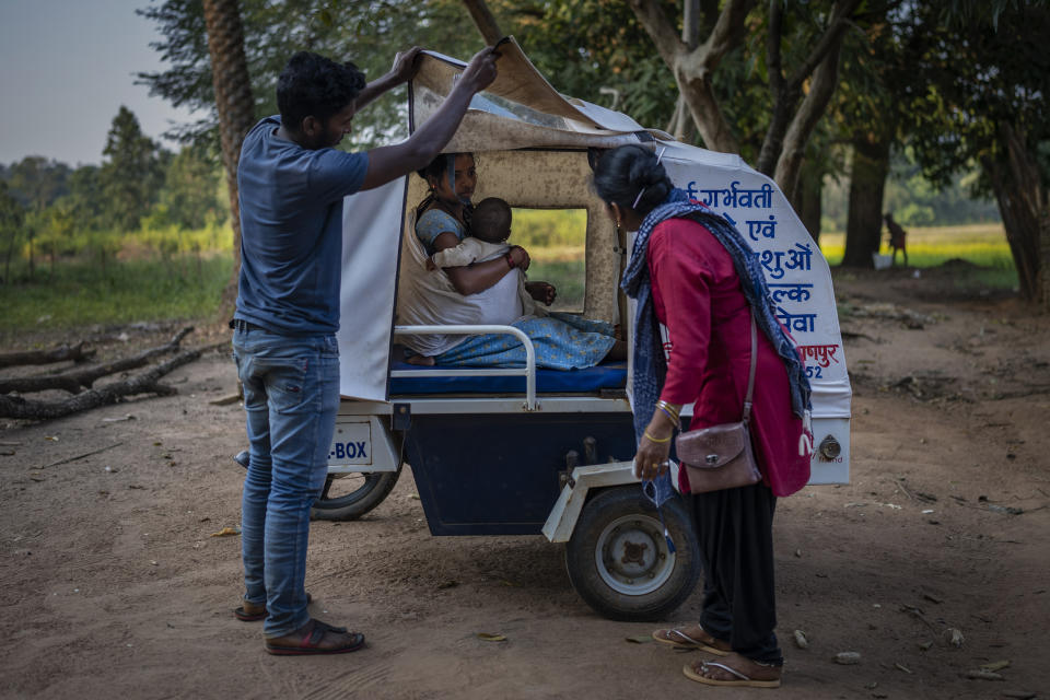 Phagni Poyam, 23, a nine months pregnant woman and her son sit inside a motorbike ambulance outside her home in Kodoli, a remote village near Orchha in central India's Chhattisgarh state, Nov. 15, 2022. These ambulances, first deployed in 2014, reach inaccessible villages to bring pregnant women to an early referral center, a building close to the hospital where expectant mothers can stay under observation, routinely visit doctors if needed until they give birth. Since then the number of babies born in hospitals has doubled to a yearly average of about 162 births each year, from just 76 in 2014. The state has one of the highest rates of pregnancy-related deaths for mothers in India, about 1.5 times the national average, with 137 pregnancy related deaths for mothers per 100,000 births. (AP Photo/Altaf Qadri)