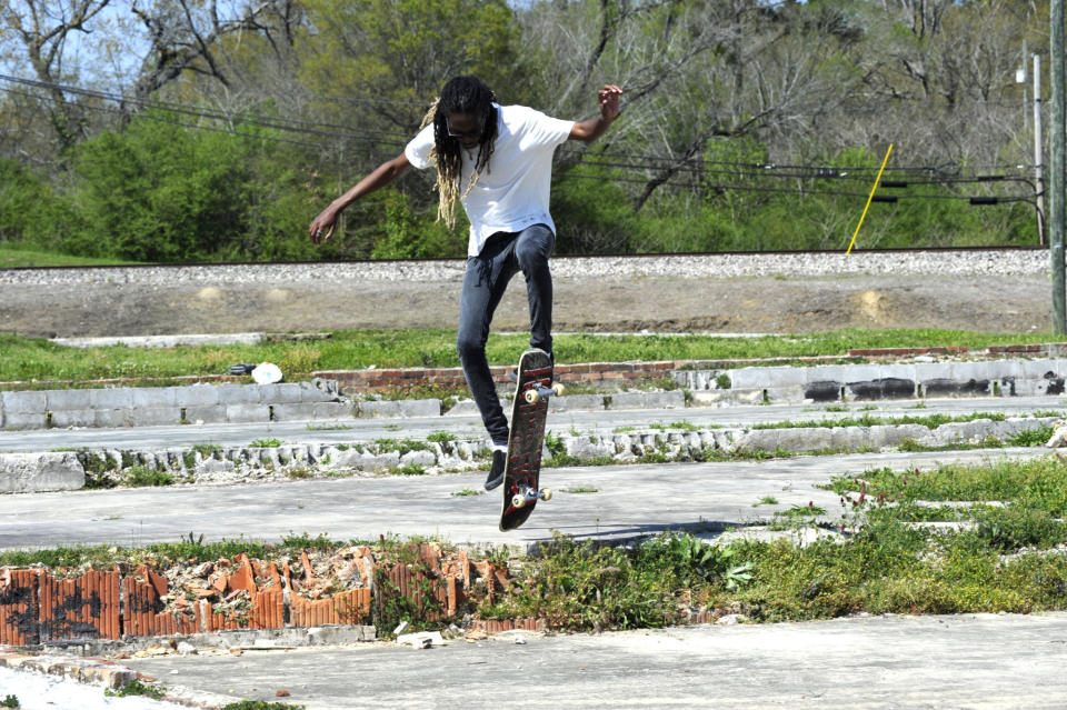 Austin Thomas skateboards on Monday, April 5, 2021, in Cordova, Ala., on weedy building foundations that remain a decade after a tornado badly damaged the town's downtown on April 27, 2011. (AP Photo/Jay Reeves)