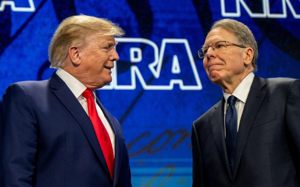 Former US President Donald Trump greets Wayne LaPierre during the NRA's annual convention in 2022