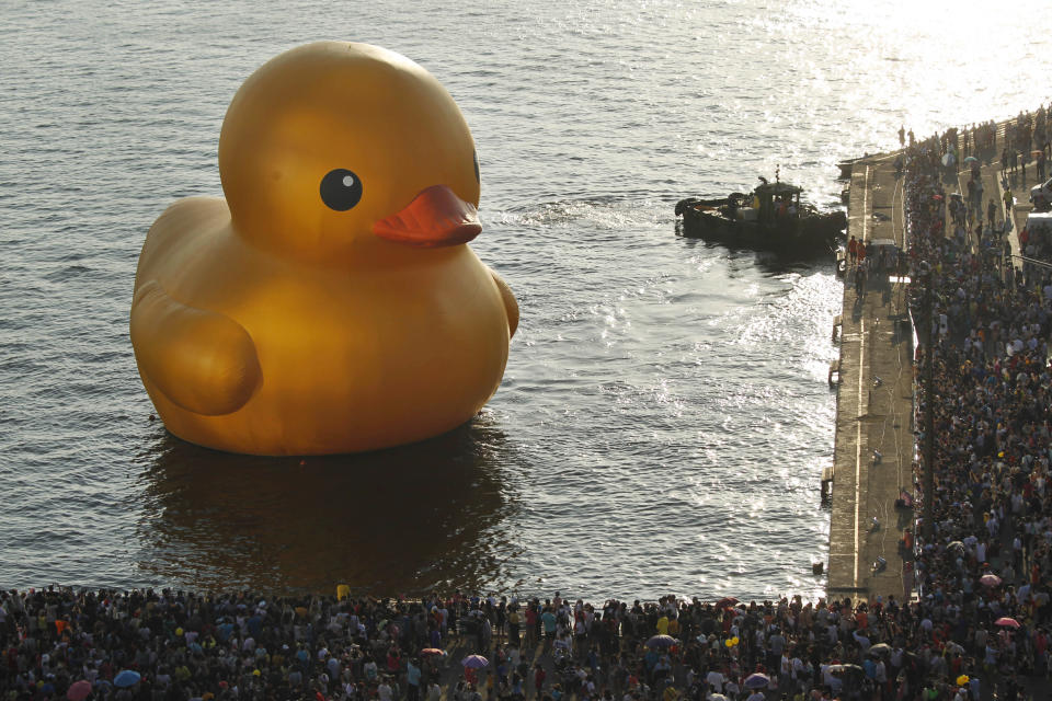 Thousands of visitors surround a giant yellow duck in the port of Kaohsiung, Taiwan, Thursday, Sept. 19, 2013. Kaohsiung is the first leg of the Taiwan tour for Dutch artist Florentijn Hofman's famous 18 meter (59 foot) yellow duck, a gigantic version of the iconic bathtub toy used by children around the world. (AP Photo/Wally Santana)