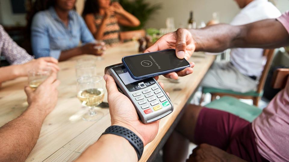 Person paying at restaurant using contactless phone app