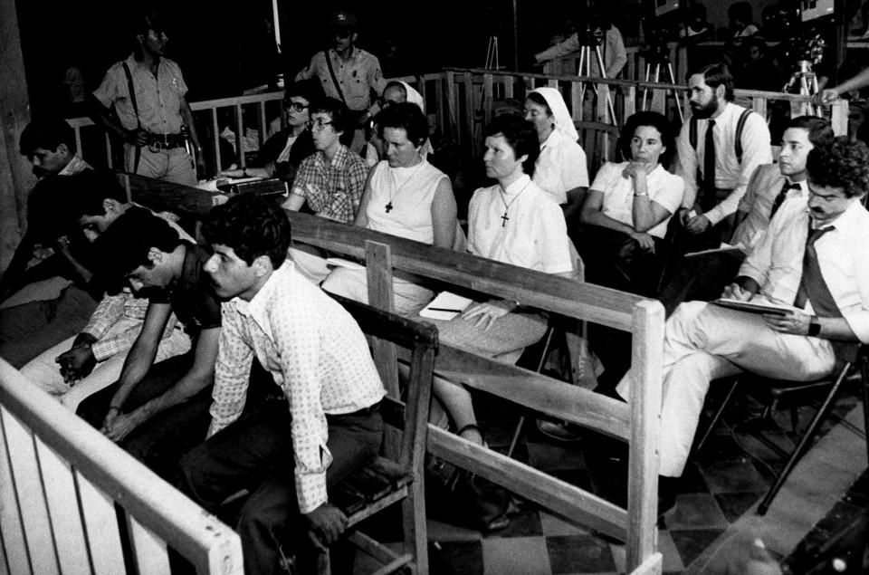 The five accused former National Guardsmen sit beside nuns of the Maryknoll order at court in Zacatecoluca, El Salvador, in 1984. (Luis Romero / AP)