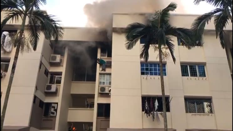 A man was spotted standing on a fourth-floor window ledge at Block 138 Bedok Reservoir Road on Monday (20 February) to escape the smoke from the unit. (PHOTO: Amrit Pal)