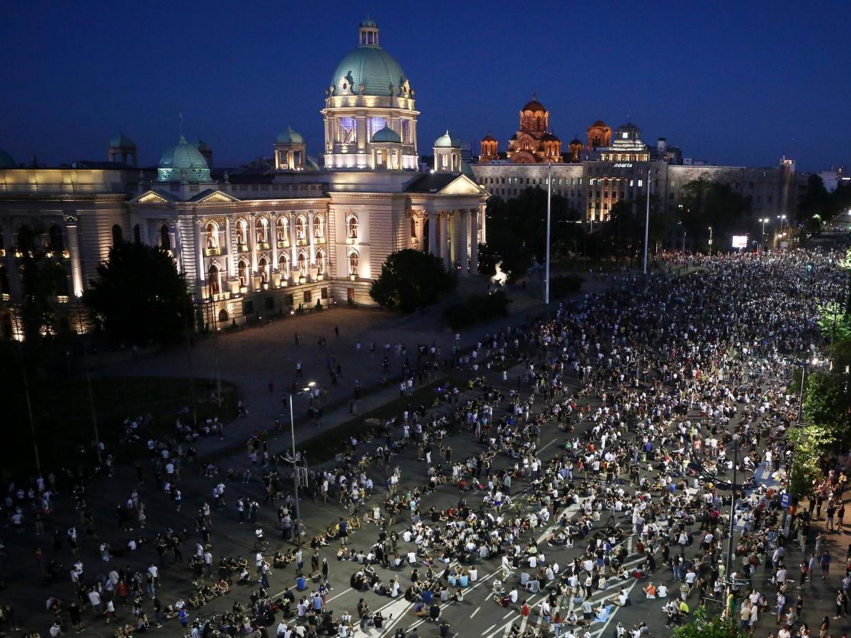 Demonstrators peacefully sit on the street in front of the parliament during a protest in Belgrade: Olive Bunic/AFP via Getty Images