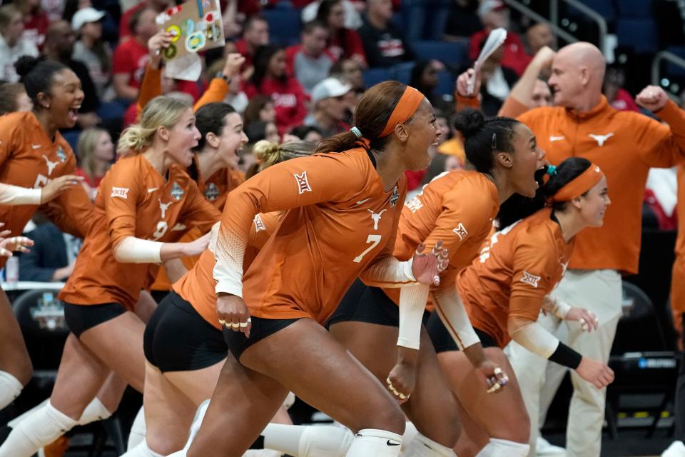 Texas middle blocker Asjia O'Neal and her teammates rush onto the court after the Longhorns closed out a 3-1 win over Wisconsin in a NCAA women's volleyball national semifinal Thursday in Tampa, Fla. With the win, Texas advances to face Nebraska in Sunday's national championship.