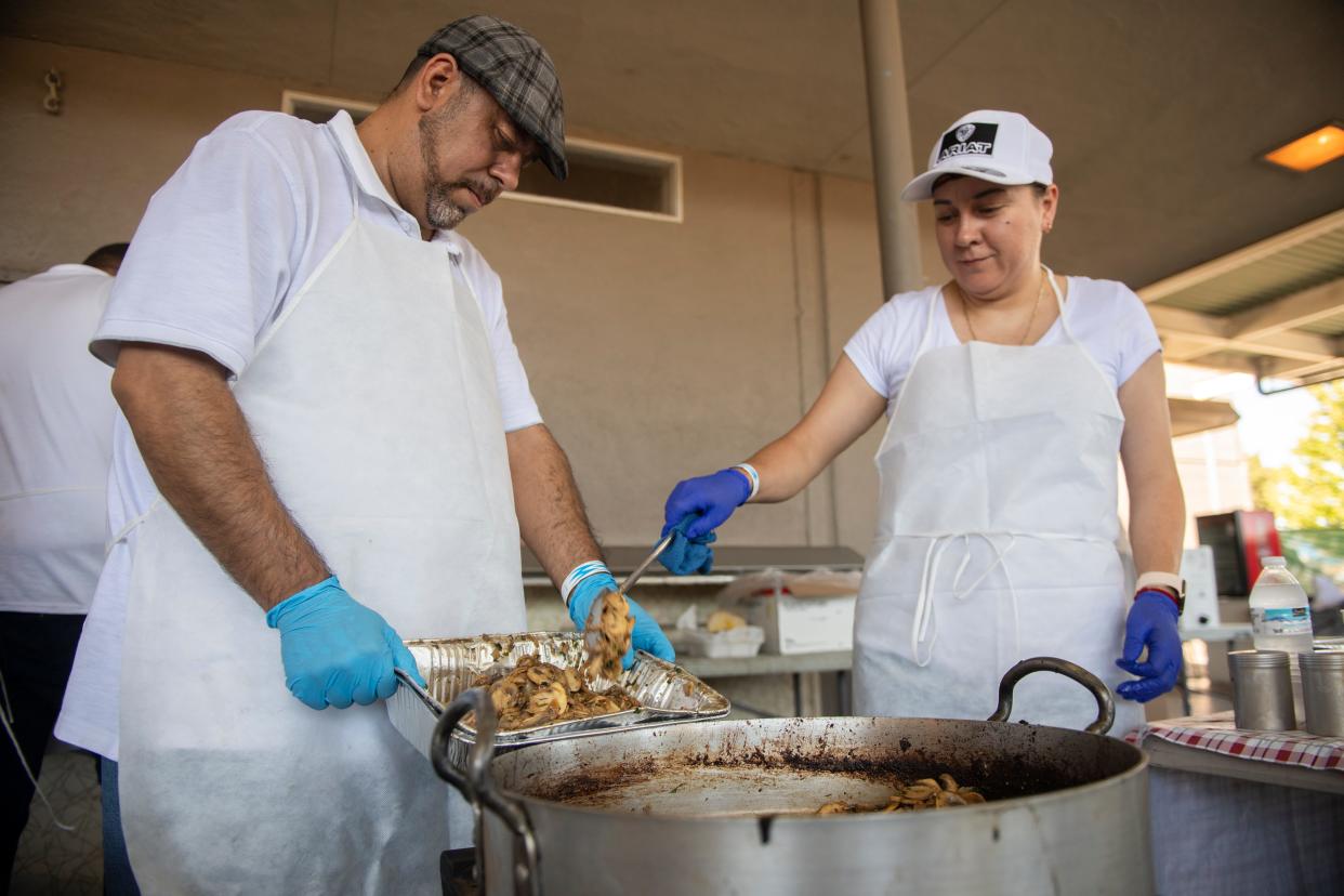 Juan Rubalcaba, left, and Lupe Castorena cook garlic mushrooms at the Cali Garlic Alley at the first California Garlic Festival at the San Joaquin County Fairgrounds in Stockton on Saturday.