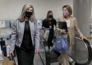 Sen. Joni Ernst, R-Iowa, left, and Sen. Shelley Moore Capito, R-W.Va., head to the chamber as the Senate holds a voting marathon on the Democrats' $1.9 trillion COVID-19 relief bill that's expected to end with the chamber's approval of the measure, at the Capitol in Washington, Friday, March 5, 2021. (AP Photo/J. Scott Applewhite)