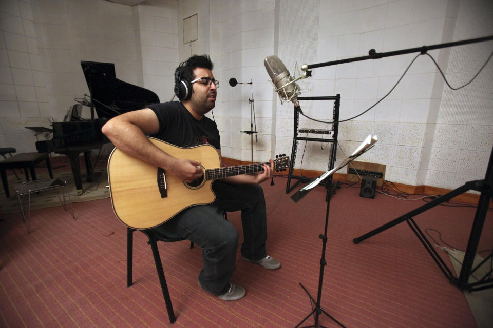 In this picture taken on Tuesday, Feb. 5, 2013, Iranian musician Danial Izadi, a member of a band called "Accolade," performs for a studio recording in Tehran, Iran. Heavy metal guitarists jamming in basements. Headphone-wearing disc jockeys mixing beats. Its an underground music scene that is flourishing in Iran, despite government restrictions. (AP Photo/Vahid Salemi)