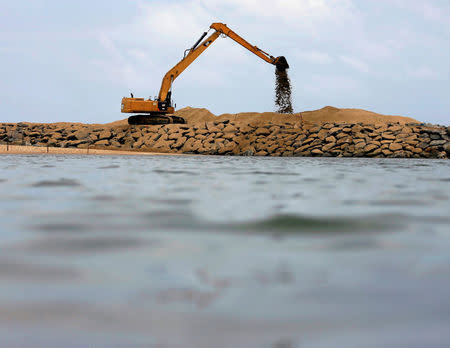 An excavator works on land reclamation at "Colombo Port City" construction site, which is backed by Chinese investment, in Colombo, Sri Lanka, August 9, 2016. REUTERS/Dinuka Liyanawatte/File Photo