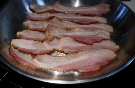Bacon is fried up in a pan in a kitchen in this photo illustration in Golden, Colorado, October 26, 2015. REUTERS/Rick Wilking