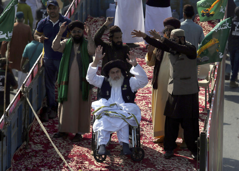 FILE - In this Saturday, Nov. 7, 2020 file photo, Khadim Hussein Rizvi, center on wheelchair, head of 'Tehreek-e-Labaik Pakistan, a religious political party, leads an anti France rally in Karachi, Pakistan. Rizvi, a radical religious cleric, who led tens of thousands in anti-France around the country, died Thursday, Nov. 19, 2020. His spokesman and a doctor at the hospital where Rizvi died said he was suffering from COVID-like symptoms but was not tested for the virus. (AP Photo/Fareed Khan, File)