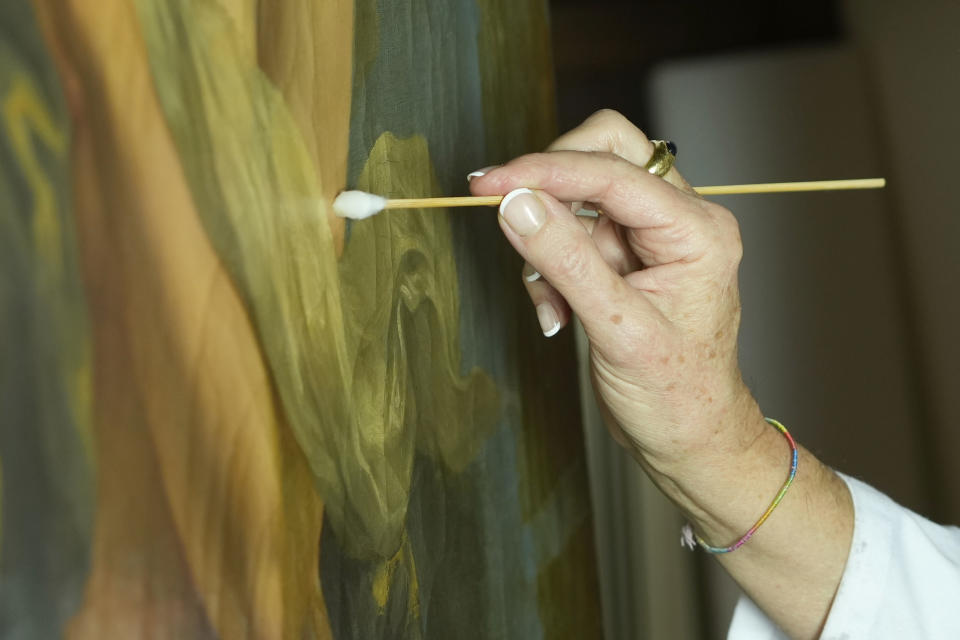 Restorer Elizabeth Wicks works on the "Allegory of Inclination", a 1616 work by Artemisia Gentileschi, in the Casa Buonarroti Museum, in Florence, Italy, Wednesday, Nov. 9, 2022. Restorers have begun a six-month project on the "Allegory of Inclination" using modern techniques including x-rays and UV infrared research to go beneath the veils painted over the original to cover nudities and discover the work as Gentileschi painted it. (AP Photo/Andrew Medichini)