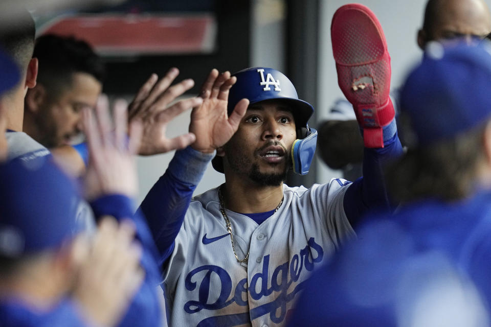 Los Angeles Dodgers' Mookie Betts is congratulated in the dugout after scoring against the Cleveland Guardians during the third inning of a baseball game Tuesday, Aug. 22, 2023, in Cleveland. (AP Photo/Sue Ogrocki)