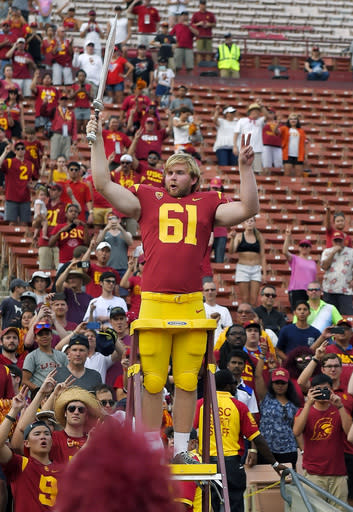 Southern California long snapper Jake Olson leads the USC Trojan Marching Band following an NCAA college football game against Western Michigan, Saturday, Sept. 2, 2017, in Los Angeles. Olson lost his sight eight years ago to a rare form of retinal cancer, but joined the USC team on a scholarship for disabled athletes and began practicing with the Trojans 2 years ago. (AP Photo/Mark J. Terrill)