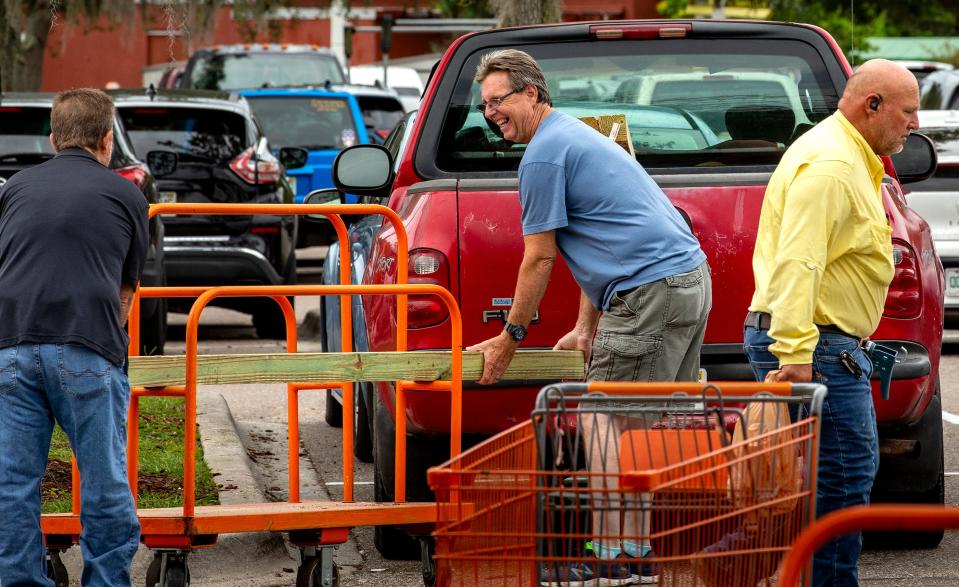 Ray Bryant, right, and Warren Bryant, left, load up construction materials at Home Depot in preparation for Hurricane Ian In Lakeland on Tuesday.