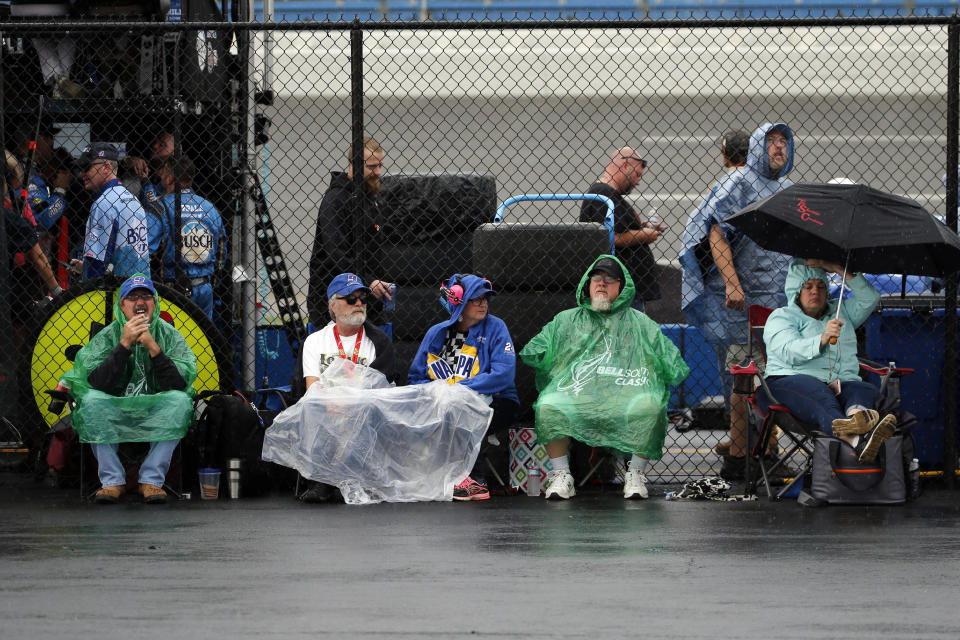 Fans sit in the rain as a NASCAR Cup Series auto race is delayed at Talladega Superspeedway in Talladega, Ala., Sunday, Oct. 13, 2019. (AP Photo/Butch Dill)