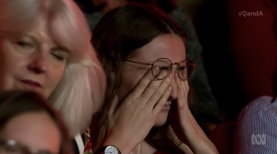 Audience member seen with head in hands. 