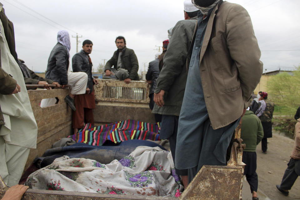 Men stand over bodies during a protest in Kunduz province north of Afghanistan, Saturday, Mar. 23, 2019. Dozens of people protested while carrying dead bodies, claiming that they had been killed during a military operation, according to a provincial official. (AP Photo/Bashir Khan Safi)