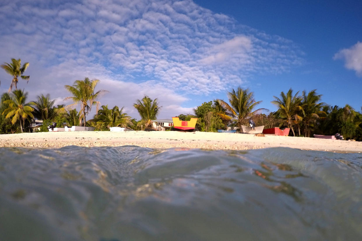 Palm trees and sand are see from the lagoon back to the shore in Funafuti, Tuvalu. Source: AAP