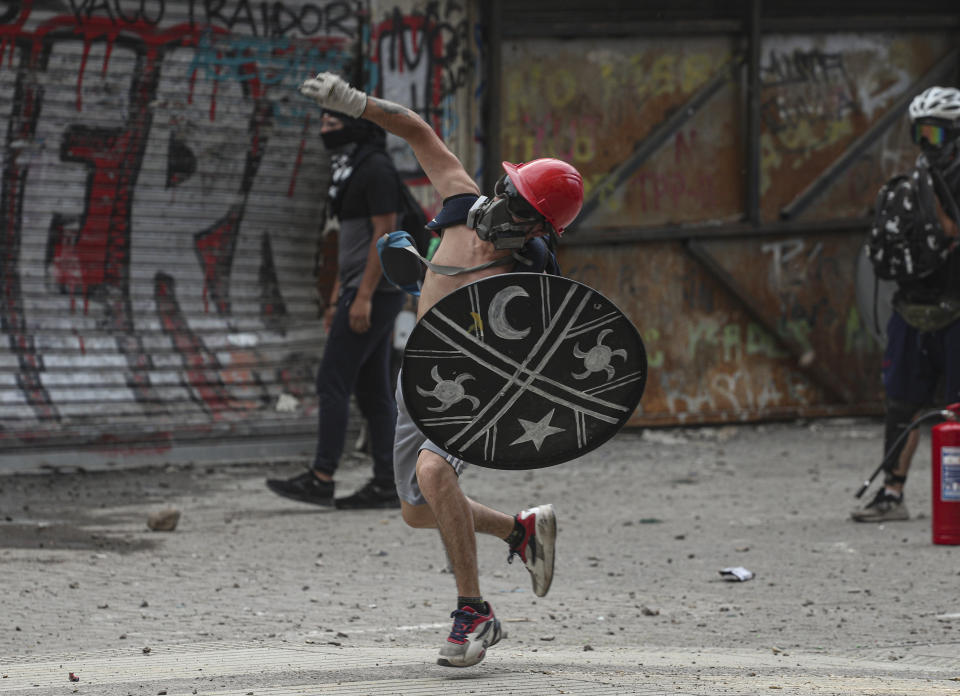 Anti-government protesters clash with police in Santiago, Chile, Monday, Nov. 18, 2019. According to the Medical College of Chile at least 230 people have lost sight after being shot in an eye in the last month while participating in the demonstrations over inequality and better social services. (AP Photo/Esteban Felix)