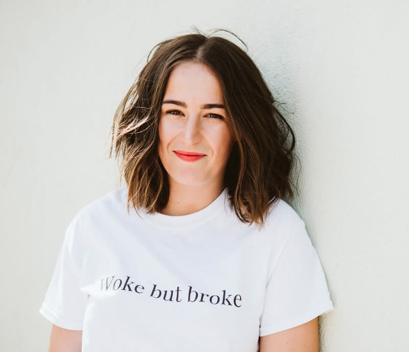 Portrait of Emma Edwards leaning against a wall.