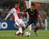 Ajax's Bojan Krkic (L) and Barcelona's Sergio Busquets (R) fight for the ball during their Champions League soccer match at Camp Nou stadium in Barcelona September 18, 2013. REUTERS/Albert Gea (SPAIN - Tags: SPORT SOCCER)