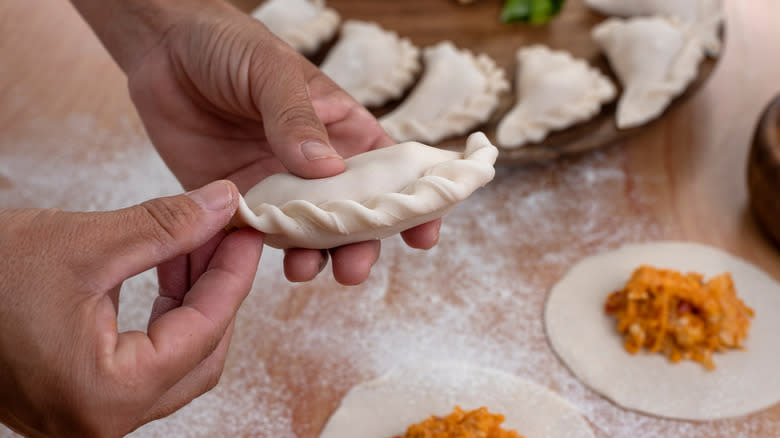 hand forming an empanada