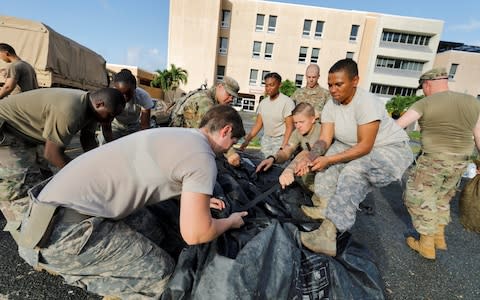 secure a portable tent as they break down a field hospital outside the Schneider Regional Medical Center while preparing to evacuate their unit in advance of Hurricane Maria - Credit: JONATHAN DRAKE/Reuters