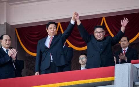Kim Jong-un clasps the hand of Chinese envoy, Li Zhanshu during the parade - Credit: Ed Jones/AFP