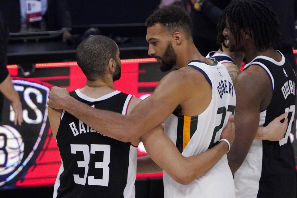 Los Angeles Clippers forward Nicolas Batum, left, of France talks with Utah Jazz center Rudy Gobert, of France, after the Clippers defeated the Jazz 131-119 in Game 6 of a second-round NBA basketball playoff series Friday, June 18, 2021, in Los Angeles. (AP Photo/Mark J. Terrill)