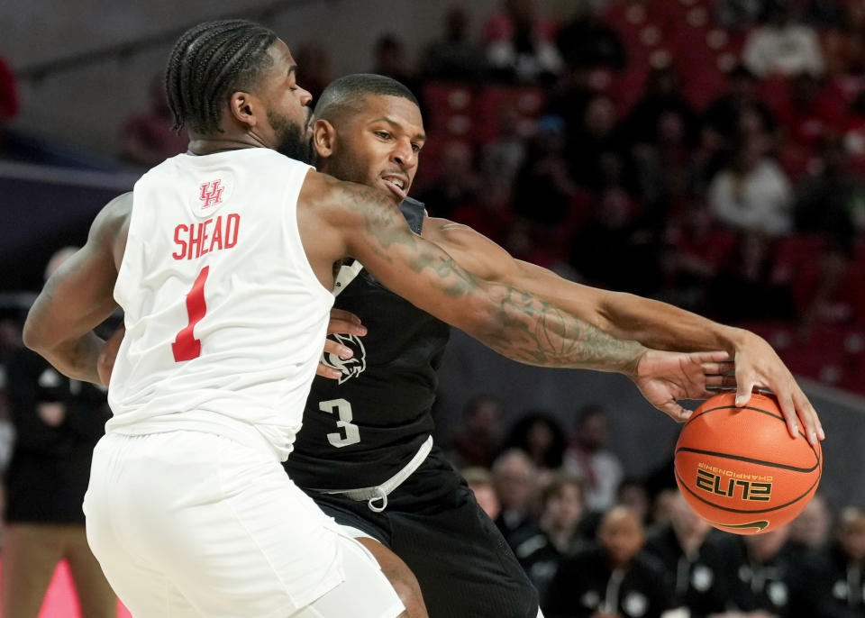 Houston guard Jamal Shead (1) tips the ball away from Rice guard Travis Evee (3) during the first half of an NCAA college basketball game at the Fertitta Center, Wednesday, Dec. 6, 2023, in Houston. (Jason Fochtman/Houston Chronicle via AP)