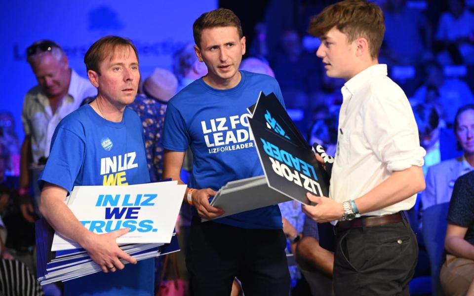 Liz Truss supporters hand out signs at this evening's hustings event in Cheltenham  - Eddie Mulholland for The Telegraph