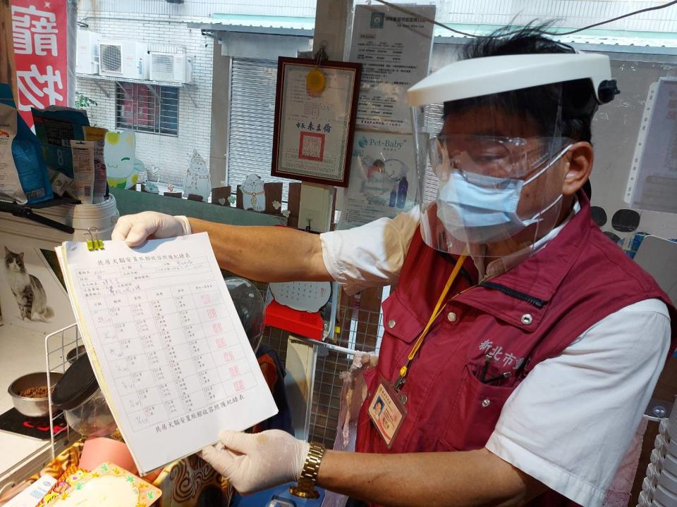 獸醫彭明發檢視收容場所每日照護表及特寵業執業執照。   圖、新北市動保處提供