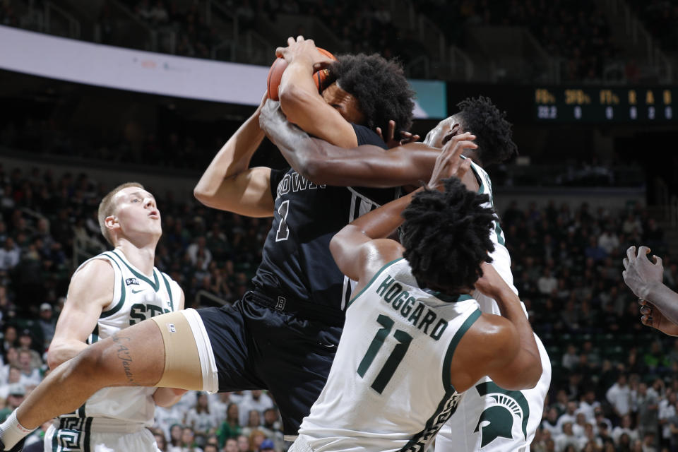 Brown's Dan Friday, center, and Michigan State's Mady Sissoko, right, and A.J. Hoggard (11) fight for a rebound as Michigan State's Joey Hauser, left, watches during the first half of an NCAA college basketball game, Saturday, Dec. 10, 2022, in East Lansing, Mich. (AP Photo/Al Goldis)