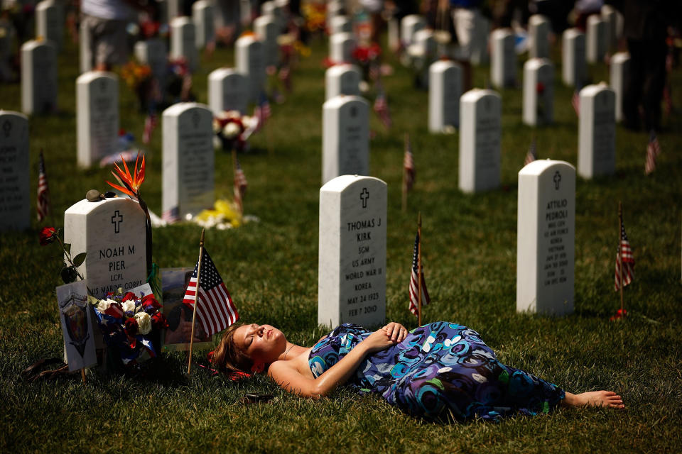 A young woman lays down on the grave of U.S. Marine Corps Lance Corporal Noah Pier on Memorial Day at Arlington National Cemetery on May 31, 2010, in Arlington, Virginia.