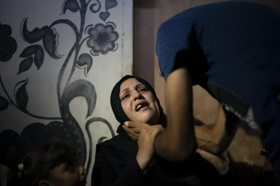 In this Sept. 15, 2018 photo, Asmaa Abdel-al reacts during the funeral of her 11-year-old son Shady Abdel-al, in Beit Lahiya, northern Gaza Strip. Isma says she told the boy not to go, but he boarded a bus to the border organized by Hamas, whose supporters were teaching him the Quran. (AP Photo/Felipe Dana)