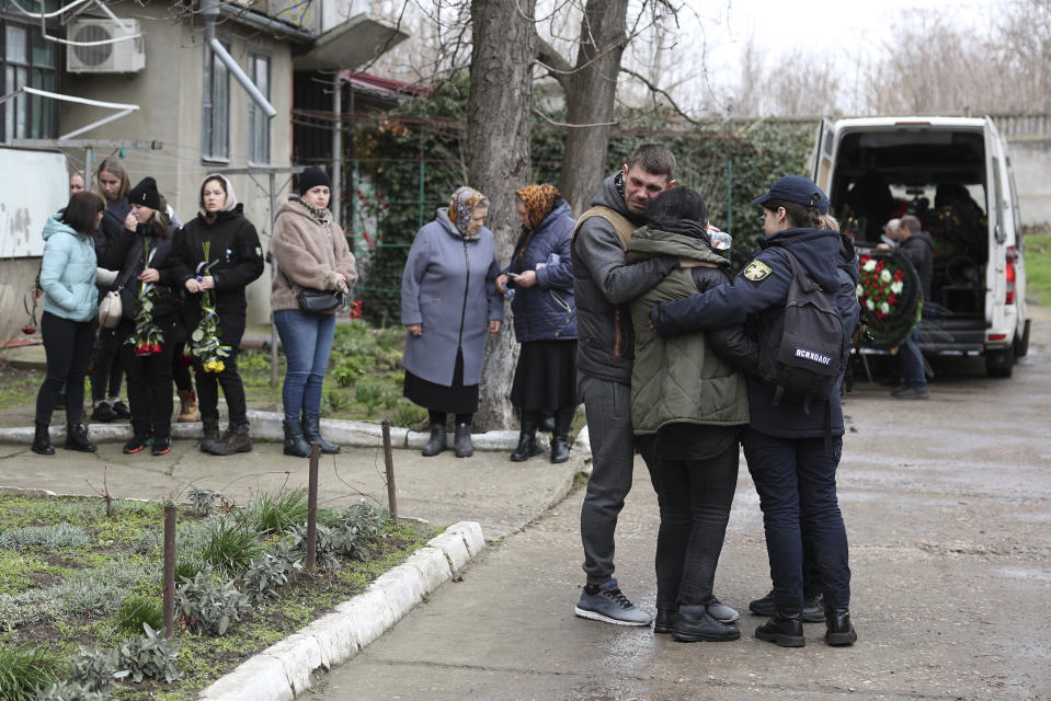 Mourners gather before the funeral of Vitaliy Alimov in Bilhorod-Dnistrovskyi, Ukraine, Monday March 18, 2024. Alimov, a firefighter, was killed in the Russian attack on Odesa on Friday March 15. (AP Photo/Victor Sajenko)