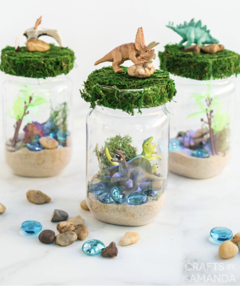 crafts for kids, mason jar with toy dinosaurs inside and greenery at the top