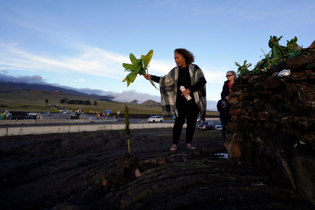 Illona Ilae, of Kailua-Kona, Hawaii, sings as she leaves an offering in front of an altar below the Mauna Loa volcano as it erupts on Dec. 1 near Hilo, Hawaii.