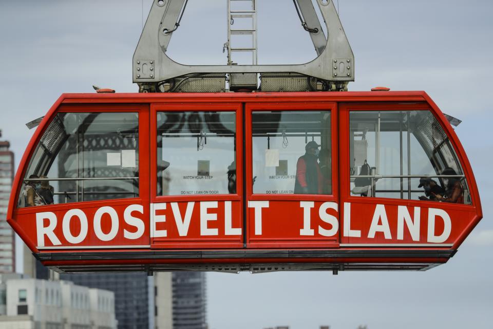 People wear protective masks during the coronavirus pandemic on the Roosevelt Island Tramway, Friday, May 22, 2020, in New York. (AP Photo/Frank Franklin II)