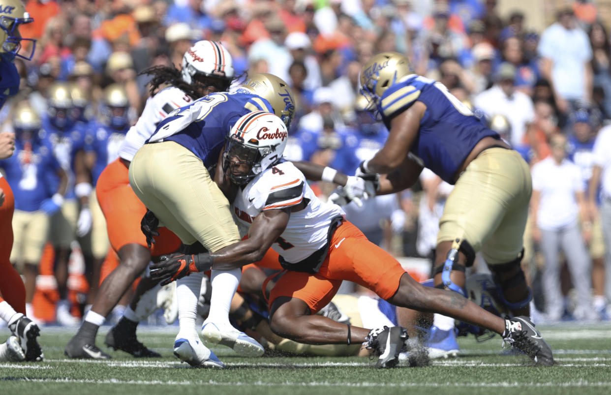 Oklahoma State linebacker Nick Martin (4) tackles Tulsa running back Anthony Watkins (23) during the first half of an NCAA college football game, Saturday, Sept. 14, 2024, in Tulsa, Okla. (AP Photo/Joey Johnson)