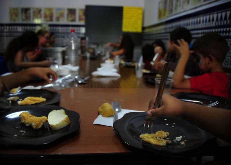 Children eat during school time in the Parish of San Antonio Abab, in Sevilla, on August 29, 2013. While other children are at the beach or campsite for their summer holidays, eight-year-old Jose Alberto is back in the classroom in the August heat