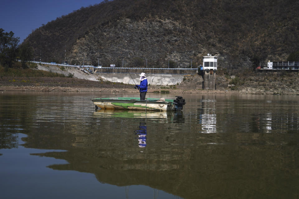 An angler fishes in the Miguel Aleman dam in Valle de Bravo, Mexico, Thursday, March 14, 2024. According to Mexico’s National Water Commission, Valle de Bravo’s reservoir has fallen to 29% of its capacity – a historical low -- compared to one year ago when it was at 52%, while the country endures a drought and has imposed restrictions on water taken from the system. (AP Photo/Marco Ugarte)