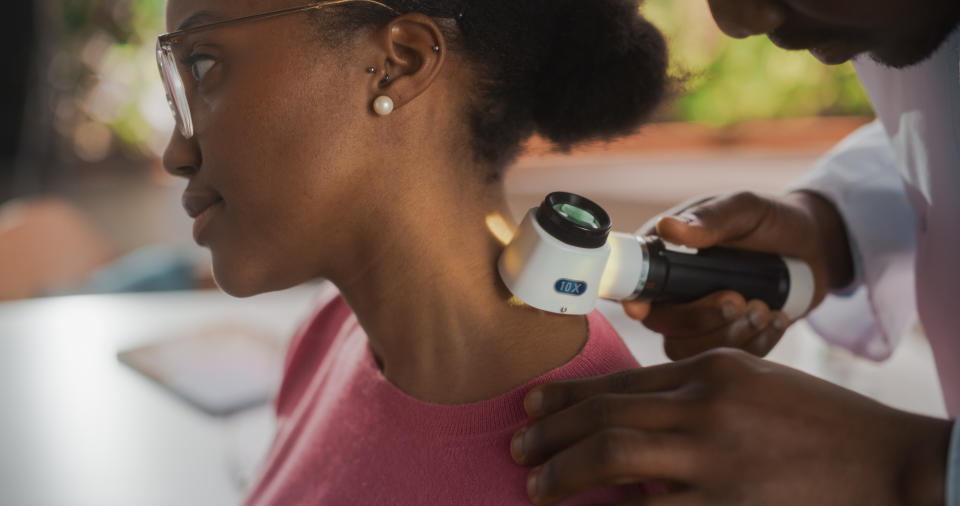 doctor checking out the skin on a woman's neck