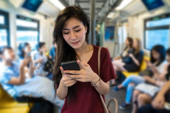 A woman using a smartphone on public transport.
