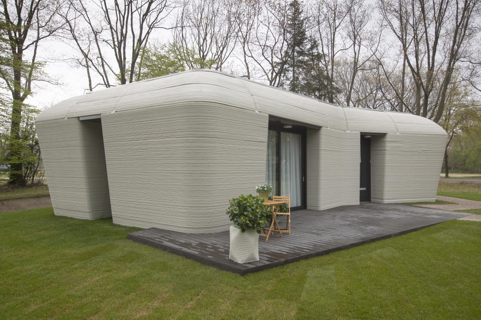 Exterior view of the 3D-printed 94-square meters (1,011-square feet) two-bedroom bungalow resembling a boulder with windows in Eindhoven, Netherlands, Friday, April 30, 2021. The fluid, curving lines of its gray walls look natural. But they are actually at the cutting edge of housing construction in the Netherlands and around the world. They were 3D printed at a nearby factory. (AP Photo/Peter Dejong)