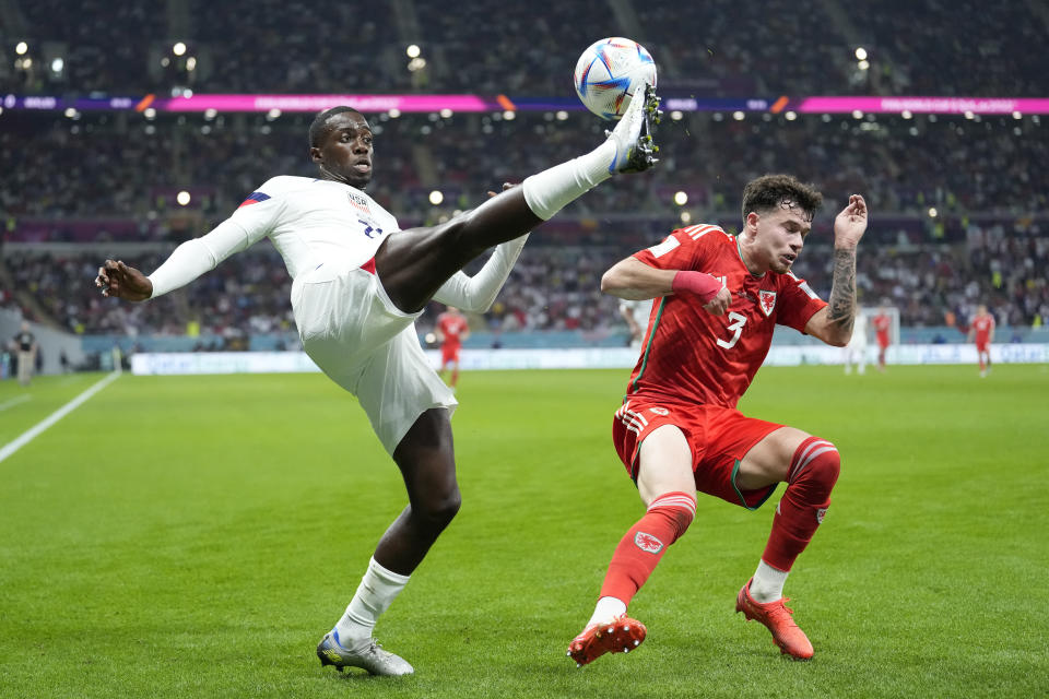 Tim Weah, de Estados Unidos (izquierda) despeja el balón delante de Neco Williams, de Gales, durante el partido del Grupo B del Mundial que enfrentó a ambos equipos, en el estadio Ahmad Bin Ali en Doha, Qatar, el 21 de noviembre de 2022. (AP Foto/Ashley Landis)